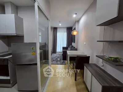 Modern apartment interior with open kitchen and cozy living area, featuring sleek furniture and stylish lighting.