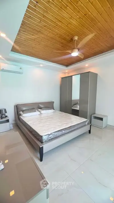 Modern bedroom with sleek furniture and wooden ceiling accent