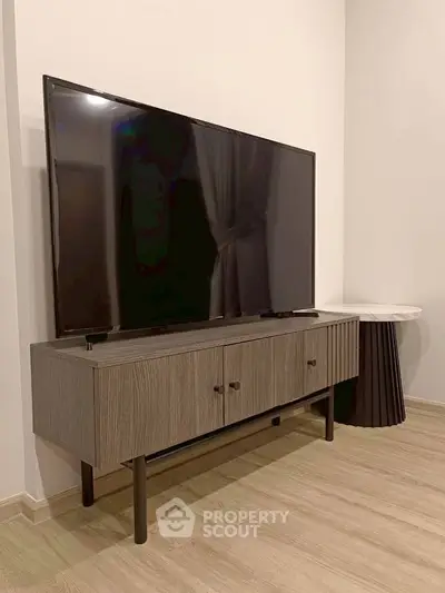 Modern living room with sleek TV stand and large flat-screen TV, perfect for entertainment.