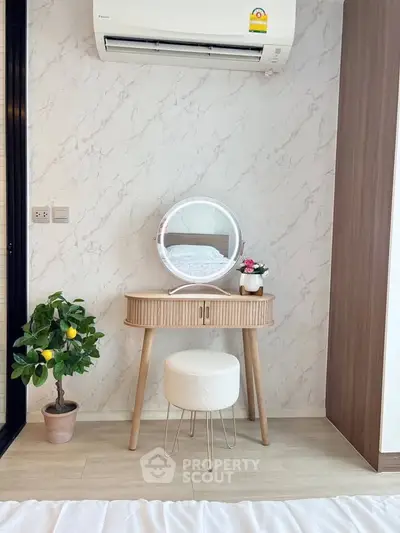 Stylish bedroom corner with vanity, stool, and air conditioning unit.