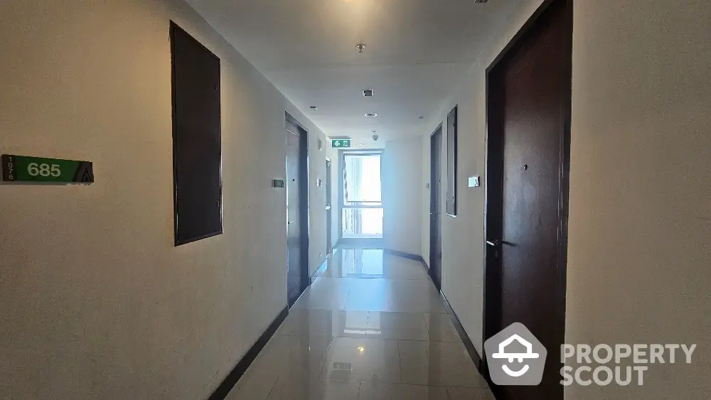 Modern apartment hallway with glossy floors and numbered doors