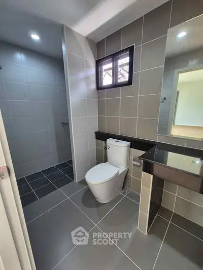 Modern bathroom with sleek tiles and contemporary fixtures in a stylish real estate property.