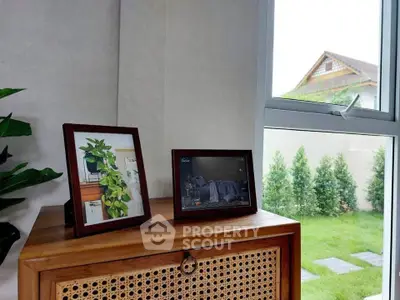 Charming interior with wooden cabinet and garden view through window, perfect for cozy living.