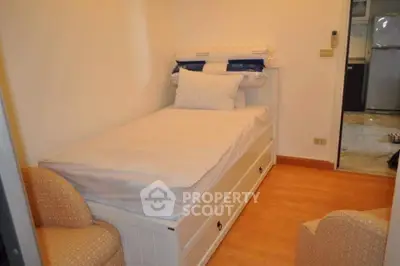 Cozy small bedroom with single bed and armchairs, adjacent to a modern kitchen.