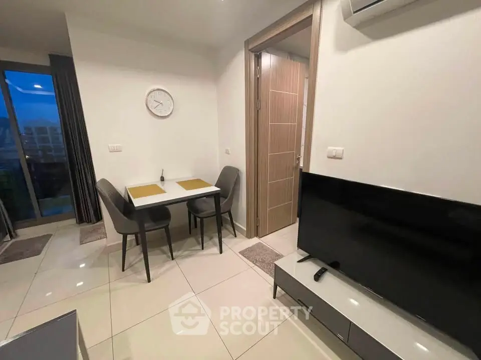 Modern apartment interior with dining area and TV, featuring sleek furniture and stylish decor.