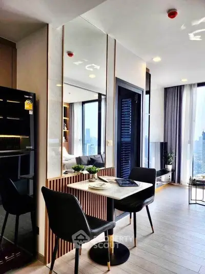 Modern apartment interior with dining area and city view, featuring sleek furniture and natural light.