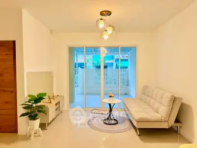 Modern living room with stylish sofa and sliding glass doors leading to a spacious balcony.