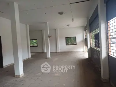 Spacious commercial space with large windows and tiled flooring, ideal for retail or office use.