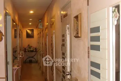 Narrow hallway with modern doors and soft lighting in a residential building.