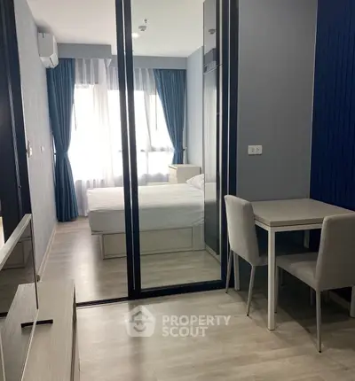 Modern bedroom with stylish decor and natural light, featuring a cozy workspace and elegant furnishings.