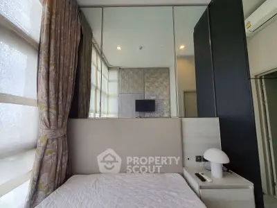 Modern bedroom with large windows and stylish decor in a contemporary apartment.