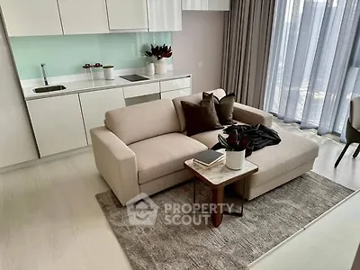 Modern living room with sleek kitchen, cozy sofa, and large windows for natural light.