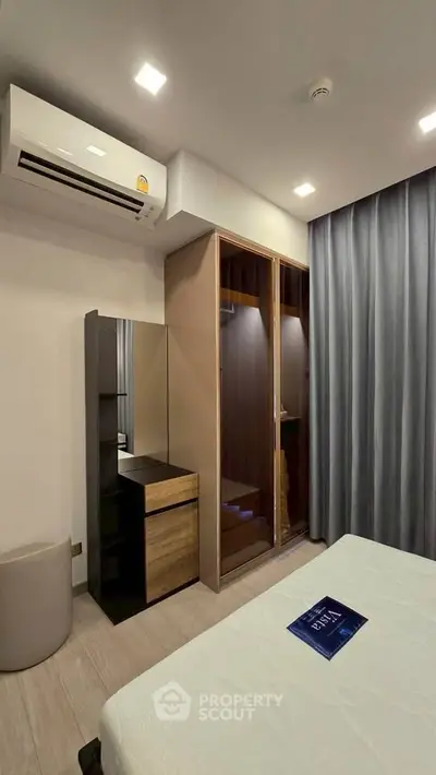 Modern bedroom with sleek wardrobe and air conditioning, perfect for comfortable living.