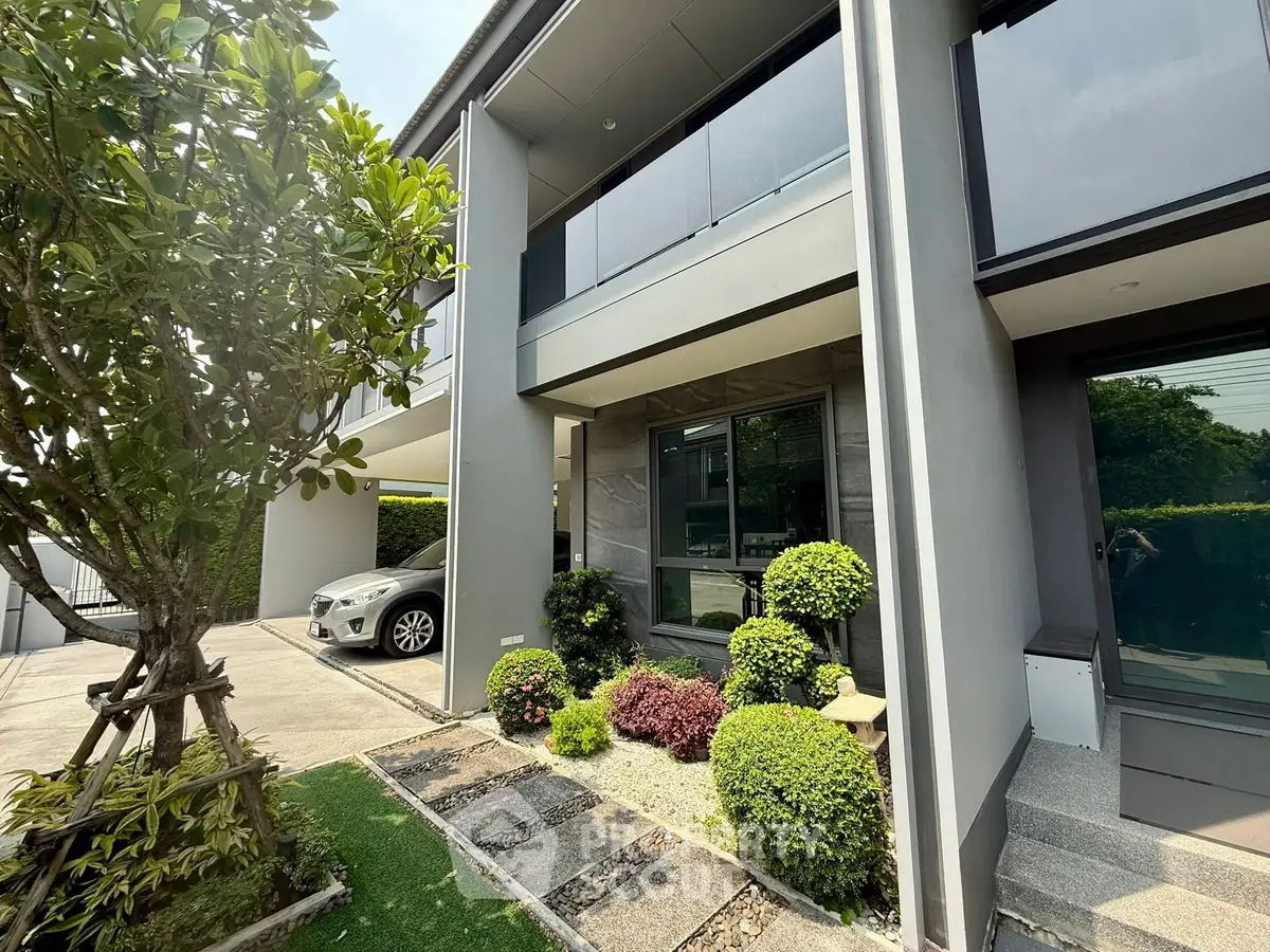 Modern house exterior with landscaped garden and driveway