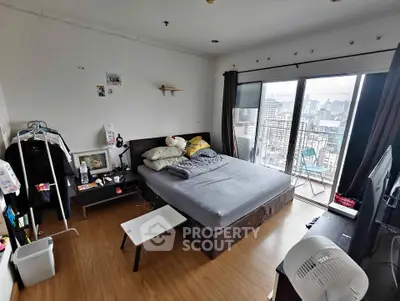 Spacious bedroom with city view and balcony access in modern apartment