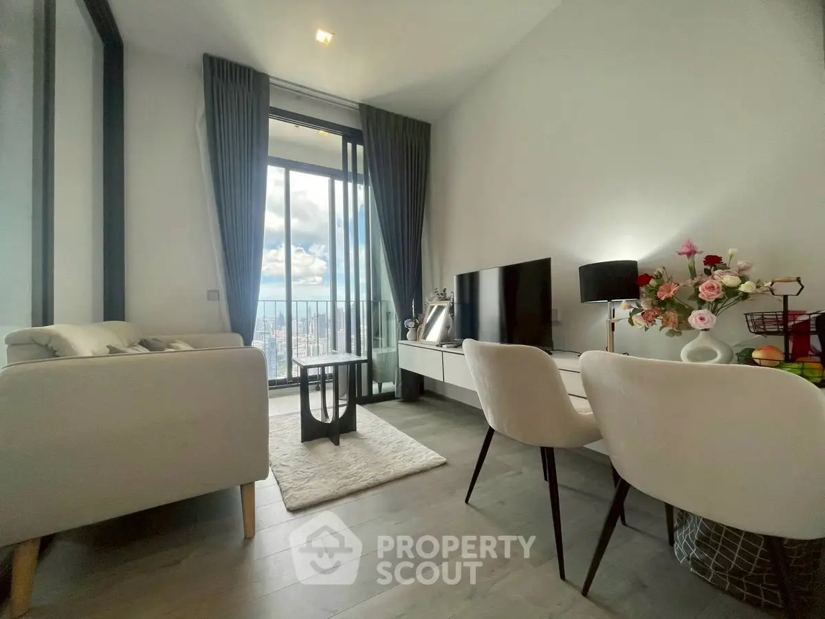 Modern living room with city view, elegant decor, and floor-to-ceiling windows.