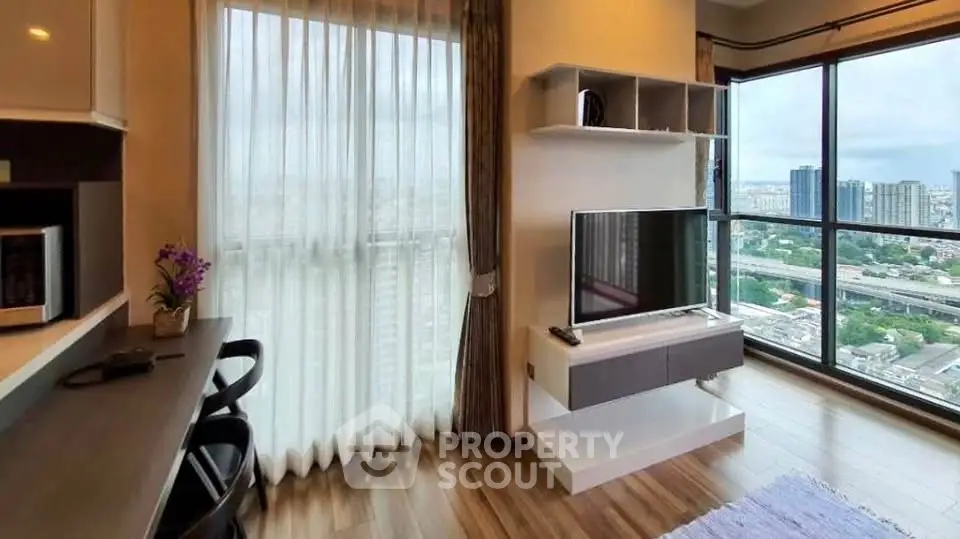 Modern living room with large windows offering stunning city views and stylish decor.