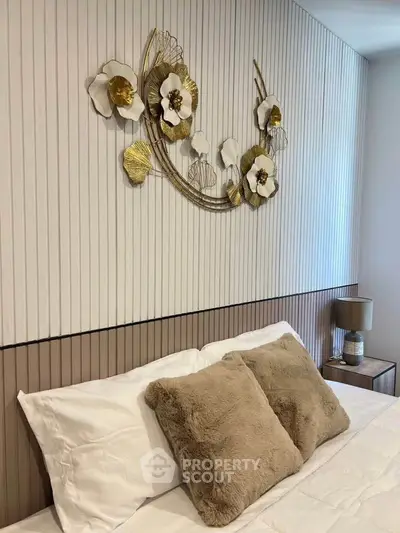 Luxurious bedroom with elegant floral wall decor and plush pillows.