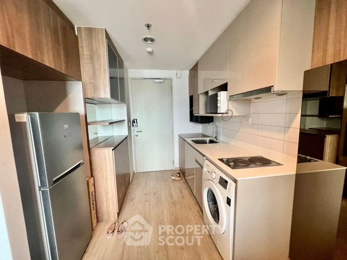 Modern kitchen with sleek appliances and wood accents in compact layout