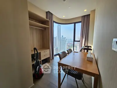 Modern study room with city view, featuring wooden desk and open closet, ideal for urban living.