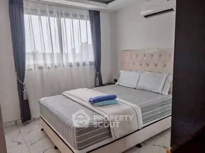Cozy bedroom with plush bed and elegant curtains in modern apartment