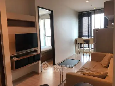 Modern living room with cozy sofa, wall-mounted TV, and natural light from large windows.