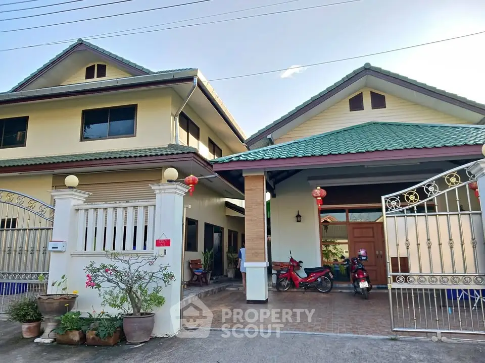 Charming two-story house with green roof and spacious driveway in a serene neighborhood.