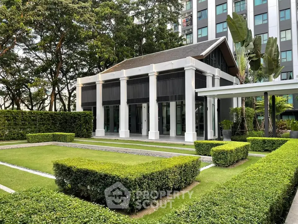 Elegant modern building with lush garden and manicured hedges in serene setting