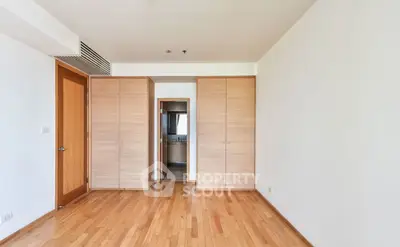 Spacious bedroom with wooden flooring and built-in wardrobes