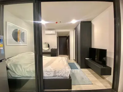 Modern bedroom with sleek design, featuring a large bed, wall-mounted TV, and stylish decor.