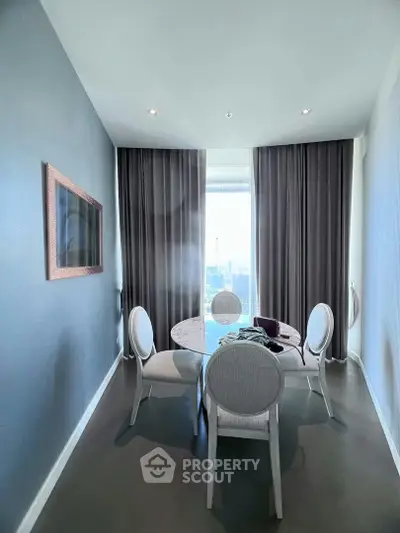 Elegant dining area with modern furniture and floor-to-ceiling windows offering stunning city views.