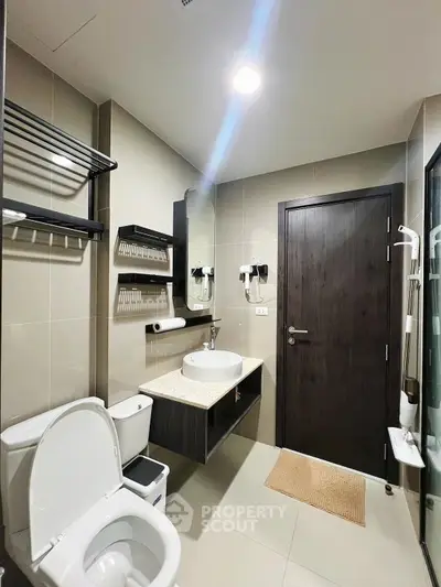 Modern bathroom with sleek fixtures and neutral tones, featuring a spacious layout and contemporary design.