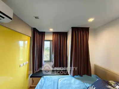 Cozy bedroom with modern design, featuring a large window and vibrant yellow wardrobe.