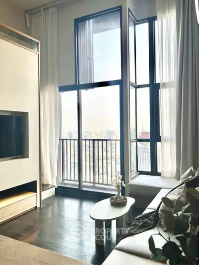 Modern living room with floor-to-ceiling windows and stunning city view.