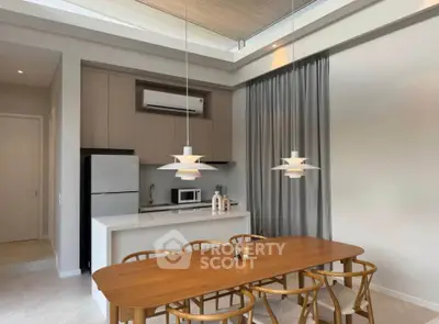 Modern kitchen with open layout, featuring sleek appliances and elegant dining area.