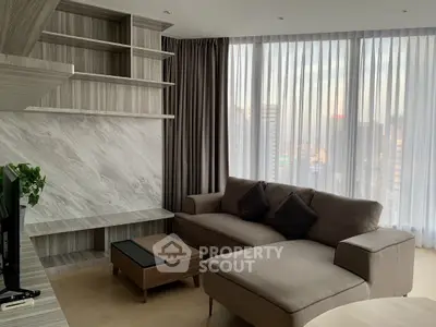 Modern living room with stylish sofa and city view through large windows.