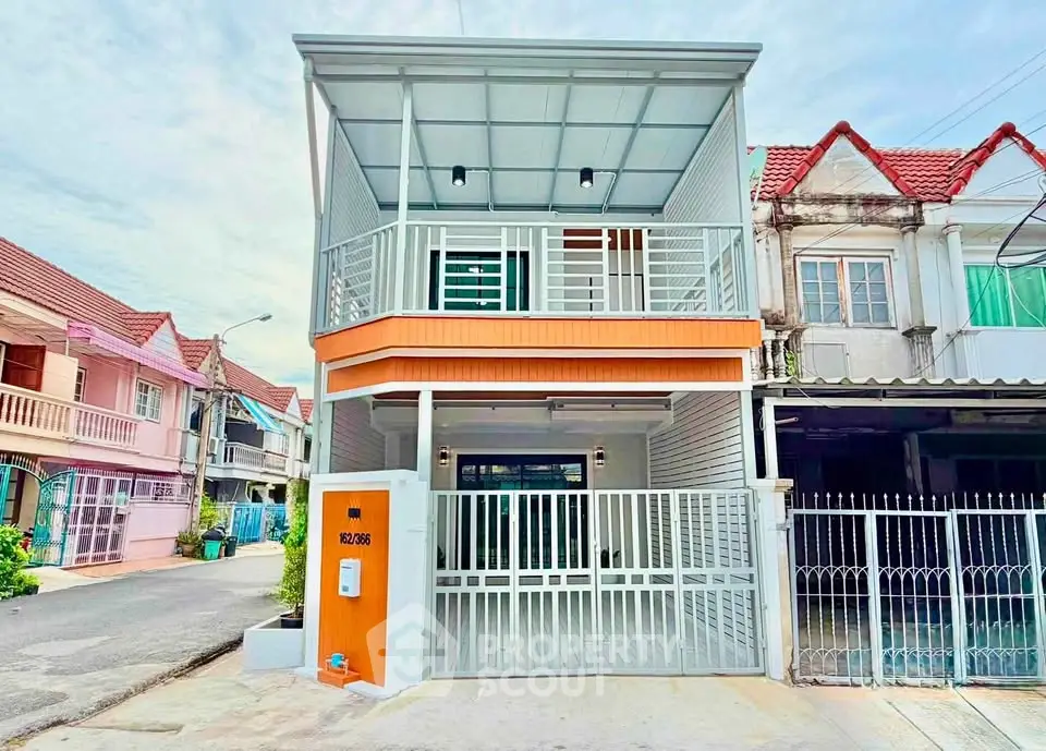 Charming two-story townhouse with modern facade and gated entrance in a vibrant neighborhood.