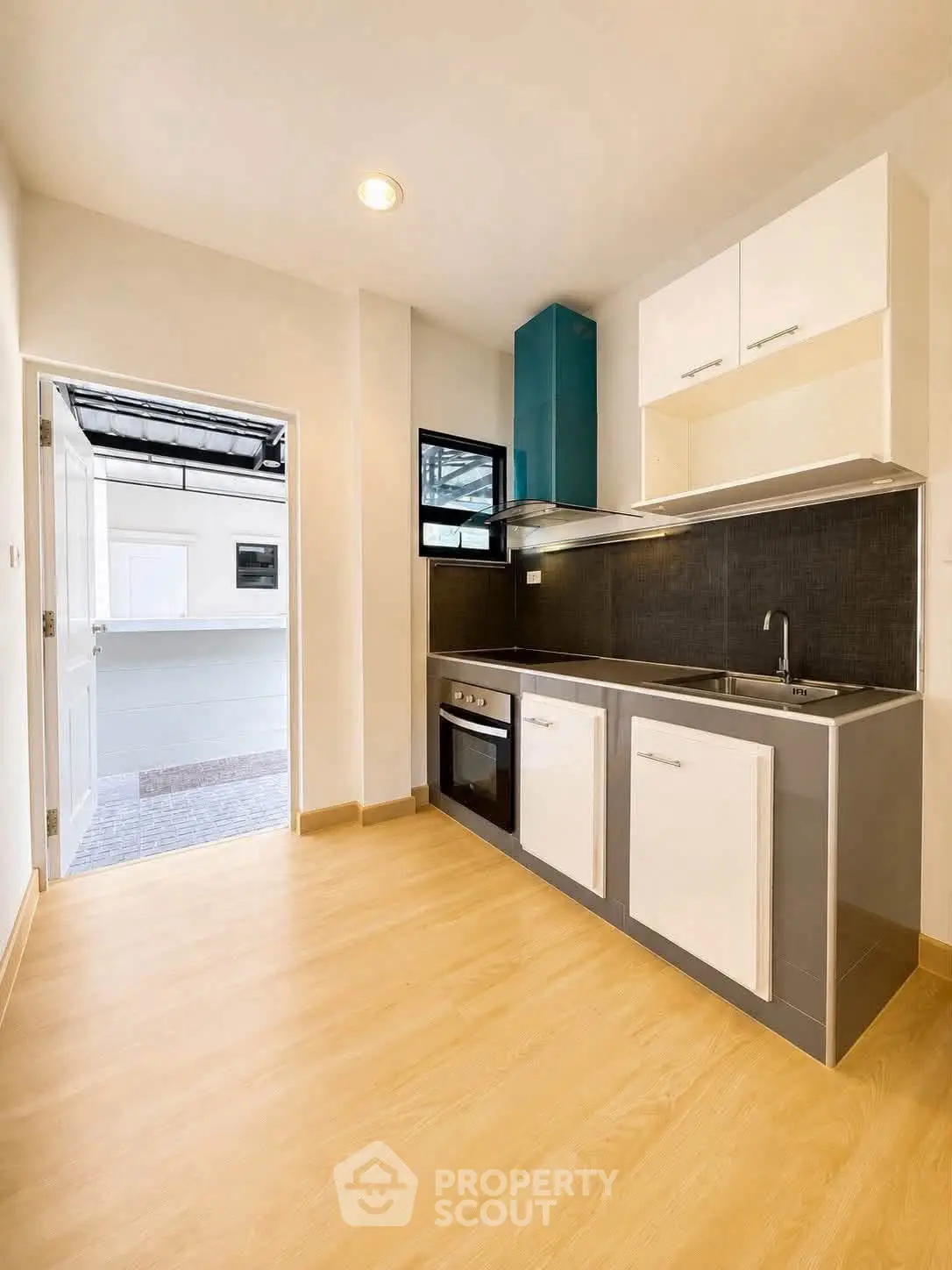 Modern kitchen with sleek cabinetry and built-in oven, featuring open layout and natural light.