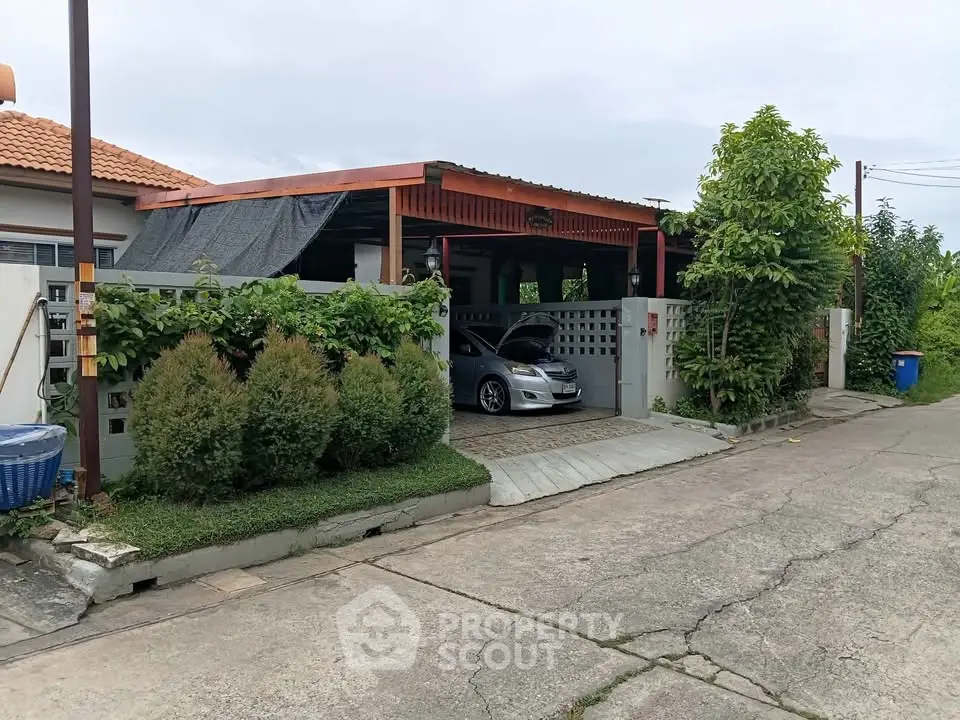 Charming suburban house with carport and lush greenery in a peaceful neighborhood.