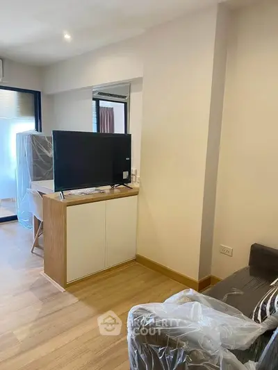 Modern living room with sleek TV setup and stylish furniture in a cozy apartment.