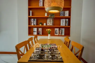 Charming dining area with wooden table, elegant chairs, and stylish bookshelf, perfect for cozy gatherings.
