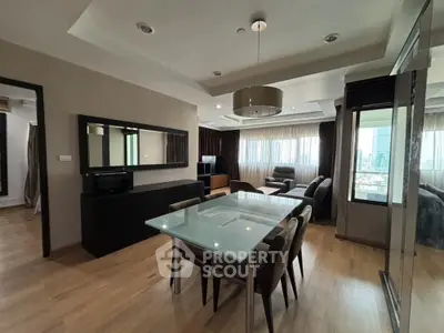 Spacious open-plan living area with modern furnishings, sleek hardwood floors, and abundant natural light from large windows, perfect for entertaining.