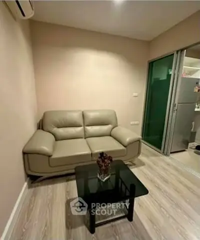 Cozy living room with modern sofa and glass coffee table, perfect for relaxation.