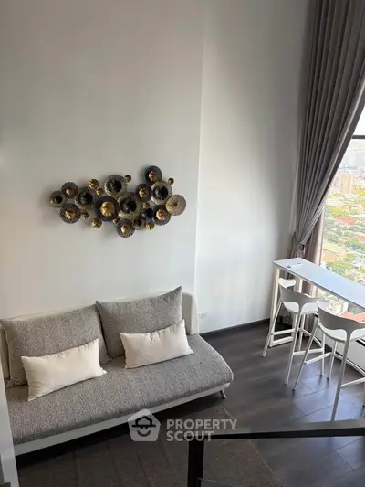 Modern living room with stylish decor and panoramic city view from high-rise apartment.