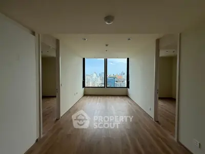 Spacious modern living room with panoramic city view and wooden flooring