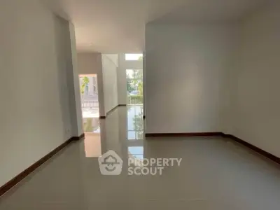 Spacious empty room with glossy floor and large windows for natural light