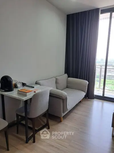 Cozy living room with sofa, table, and city view balcony