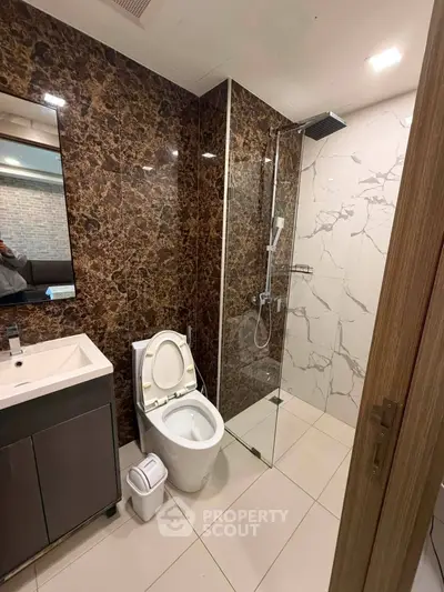 Modern bathroom with elegant marble tiles and glass shower enclosure