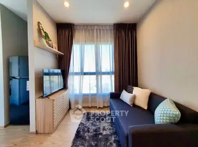 Modern living room with sleek furniture and large window, perfect for cozy relaxation.