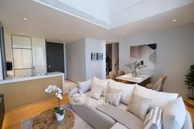 Modern open-plan living room with elegant decor and dining area in luxury apartment.